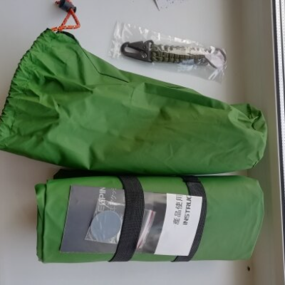 Inflatable sleeping pad packed down small next to a backpack