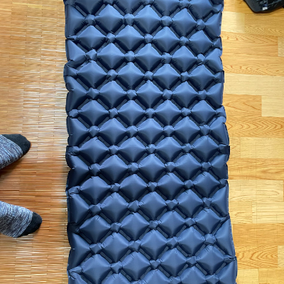 Compact rolled-up camping sleeping pad in carry bag